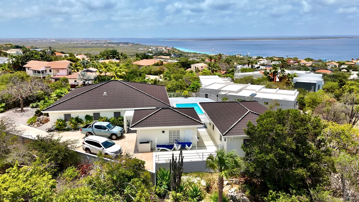 Luchtfoto van de villa met zwembad in Sabadeco, Bonaire, met de zee op de achtergrond